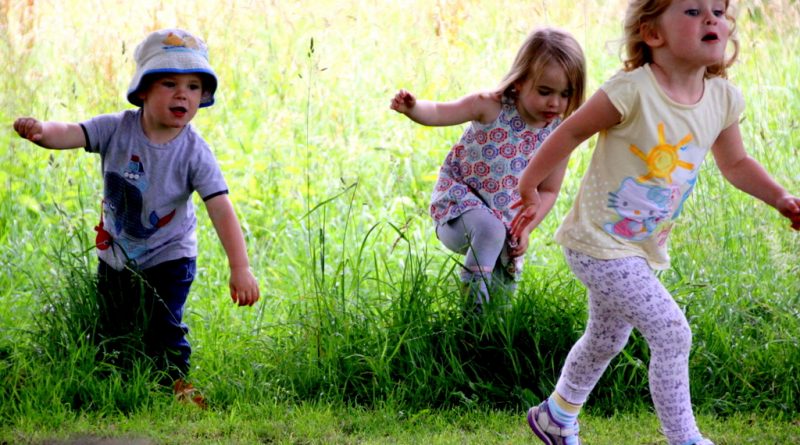 Children running through grasss in the Lustleigh Orchard